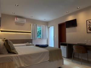 a bedroom with a bed and a desk and a computer at Hotel Elevare Niteroi in Niterói +43 photos