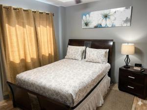 a bedroom with a bed and a table with a lamp at Paradise Place Apartments in Mount Irvine +16 photos