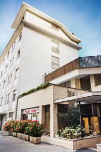 a large white building with flowers in front of it at Hotel Roma in Aosta