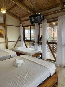 a room with three beds and a tv on the wall at Hotel Gabarra Lodge in San Vicente