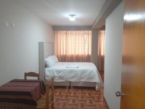 a small room with a bed and a window at Hospedaje San Isidro in Cali
