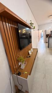 a long wooden counter in a room with flowers on it at Casa Luxo & Conforto com 4 camas e 2 quartos completa in Juazeiro do Norte