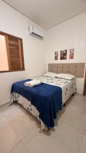 a bedroom with a bed with a blue blanket at Casa Luxo & Conforto com 4 camas e 2 quartos completa in Juazeiro do Norte