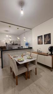 a kitchen and dining room with a table and chairs at Casa Luxo & Conforto com 4 camas e 2 quartos completa in Juazeiro do Norte