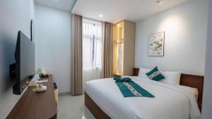 a bedroom with a large bed and a television at Cactus Villa in Dong Hoi