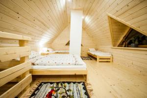 Habitación con cama en una cabaña de madera en Osada Stary Bór, en Murzasichle