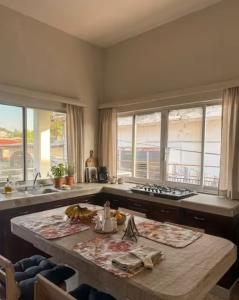 a kitchen with a table and some windows and a counter at Casa Cedro Y Olivo in Gutiérrez Zamora