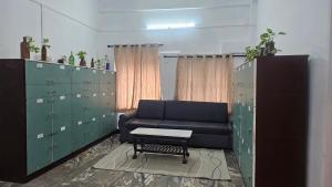a living room with a couch and some green lockers at Sea Breeze Residency in Kozhikode