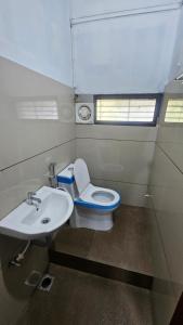 a bathroom with a toilet and a sink at Sea Breeze Residency in Kozhikode