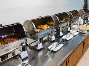 a buffet line with several trays of food at Pink Horizon Saigon Airport Hotel in Ho Chi Minh City