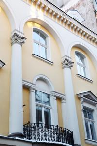 een wit gebouw met ramen en een balkon bij Audeju Apartments in Rīga