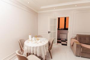 a dining room with a table and chairs and a couch at Miracle Apartment in Samarkand