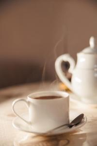 a cup of coffee on a table with a spoon at Miracle Apartment in Samarkand