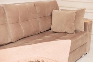 a brown leather couch with a pillow on it at Miracle Apartment in Samarkand