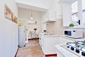 a kitchen with white cabinets and a white refrigerator at RomeAsYouLike-Monti Experience 295 in Rome
