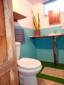 a bathroom with a toilet and a sink at Casa Almendros in Cabuya