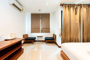 a bedroom with a bed and two chairs and a desk at XXYon INN Sukhumvit 4 - ยอน อินน์ 4 in Bang Kapi
