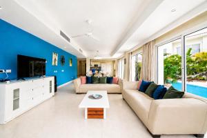 a living room with a couch and a tv at Special offer! Villa Bueno with private pool&beach in Punta Cana