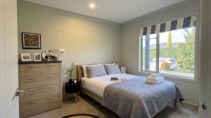 a bedroom with a bed and a window at The Orchard Escape - Cromwell in Cromwell