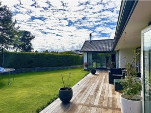 a backyard with a wooden deck with potted plants at The Orchard Escape - Cromwell in Cromwell