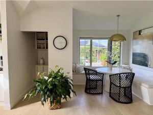 a dining room with a table and a clock on the wall at The Orchard Escape - Cromwell in Cromwell