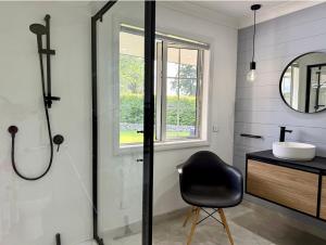 a bathroom with a black chair and a sink at The Orchard Escape - Cromwell in Cromwell +4 photos