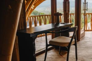 a desk with a chair in front of a balcony at Mandala Eco Resort Lombok in Selong Belanak
