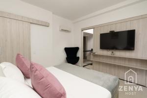 a hotel room with a bed and a flat screen tv at Hotel On By Zenya Host in Cali