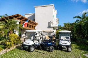 two golf carts parked in front of a house at Special offer! Villa Bueno with private pool&beach in Punta Cana +55 photos