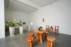 a room with wooden seats and tables and chairs at Urbanview Hotel Nimara Ngawi by RedDoorz in Ngawi