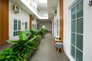 a corridor of an office building with plants at Urbanview Hotel Nimara Ngawi by RedDoorz in Ngawi