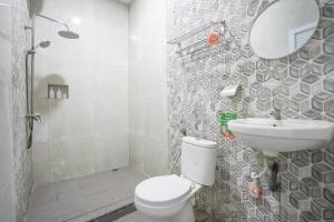 a bathroom with a toilet and a sink and a shower at Urbanview Hotel Nimara Ngawi by RedDoorz in Ngawi +57 photos