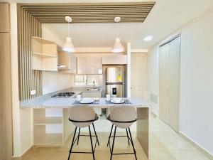 a kitchen with a large island with two stools at Capriela Serena del Mar in Cartagena de Indias