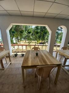 a wooden table and chairs in a room with a large window at Ella Solara Heaven in Ella