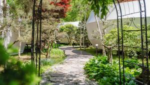 a path in a garden with trees and a building at Gapyeong Pine4rest Glamping in Gapyeong