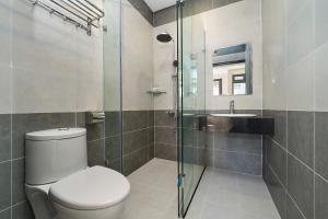 a bathroom with a toilet and a glass shower at Hotel Duy Phương 2 in Da Lat