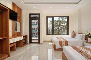 a hotel room with two beds and a television at Hotel Duy Phương 2 in Da Lat