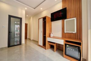 a room with a tv on a wall with a desk at Hotel Duy Phương 2 in Da Lat +14 photos