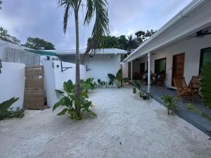 a courtyard of a house with a palm tree at Salt Serenity in Thoddoo