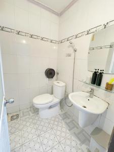 a white bathroom with a toilet and a sink at My Kim Hotel - Ngay Bến Ninh Kiều in Can Tho