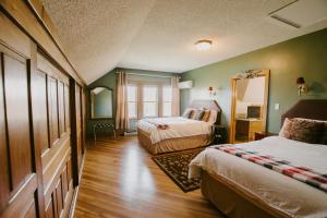 a hotel room with two beds and a mirror at The Inn at Ragged Edge in Chambersburg