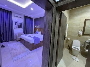 ein Schlafzimmer mit Bett und ein Badezimmer mit Toilette in der Unterkunft Stino Hotel in Ogor