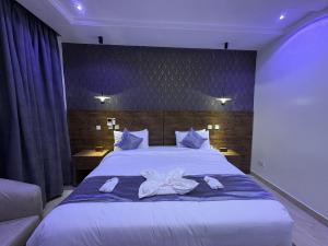 ein Schlafzimmer mit einem großen weißen Bett, auf dem Handtücher liegen in der Unterkunft Stino Hotel in Ogor