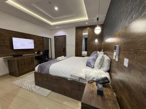 ein Schlafzimmer mit einem großen Bett und einem Fernseher in der Unterkunft Stino Hotel in Ogor