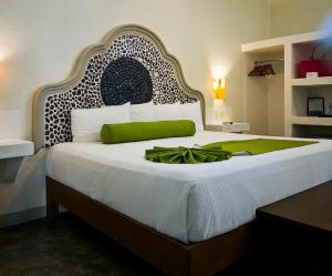 a bedroom with a large bed with a green bow on it at Paraiso Azul Hotel in Loreto +67 photos