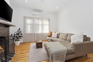 a living room with a couch and a fireplace at Barnard Bungalow in Bendigo
