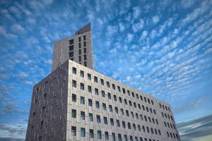 a tall white building with a sky in the background at Fosshotel Reykjavík in Reykjavík