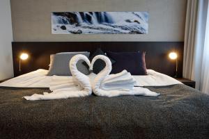 2 cigni fatti di asciugamani su un letto di Fosshotel Reykjavík a Reykjavik
