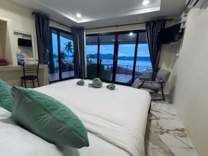 a bedroom with a large bed with a view of the ocean at Leam Sai Seaview in Ban Laem Sai