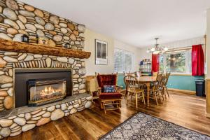 a living room with a stone fireplace and a dining table at 838 Placer Avenue home in South Lake Tahoe